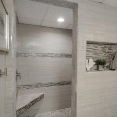 Spectacular master suite walk in shower with glass tile accents and bench