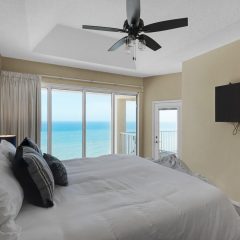 Master suite with balcony access and large flat screen tv